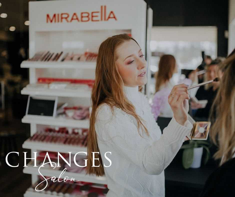 Makeup artist applies cosmetics to a client's face at Changes Salon, Mirabella products displayed.